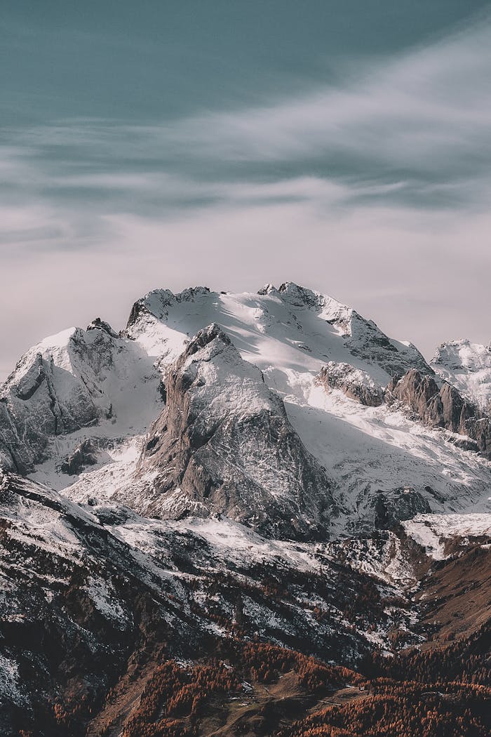 A breathtaking view of a snow-capped mountain range under a clear sky, capturing winter's beauty.